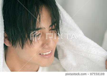 年輕人用毛巾擦乾濕頭髮 87558189