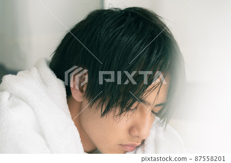 年輕人用毛巾擦乾濕頭髮 87558201