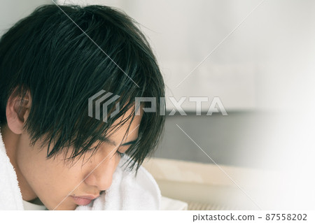 年輕人用毛巾擦乾濕頭髮 87558202