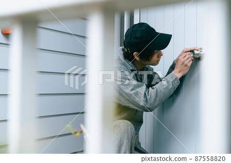 Young man repairing a door 87558820