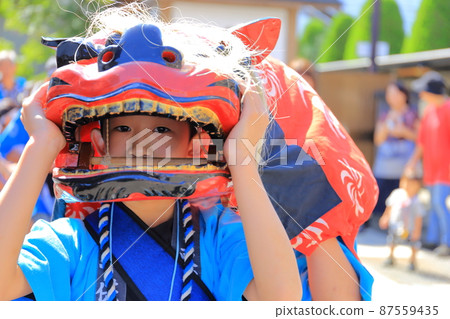一個男孩在節日里帶著獅子頭 87559435