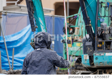 Workers doing construction work in the rain 87559837