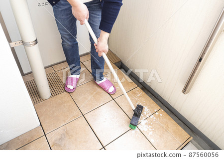 Cleaning the balcony of the apartment with a deck brush Cleaning the balcony of the apartment with a deck brush 87560056