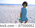 一個女孩在沙灘上撿貝殼 87560062