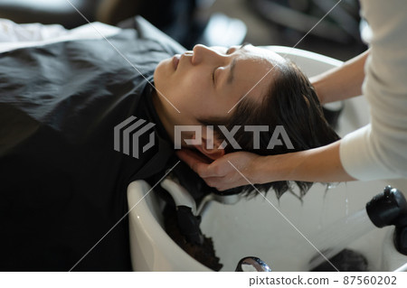 A man who gets shampooed at a beauty salon A man who gets shampooed at a beauty salon 87560202