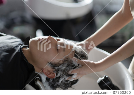 A man who gets shampooed at a beauty salon 87560260