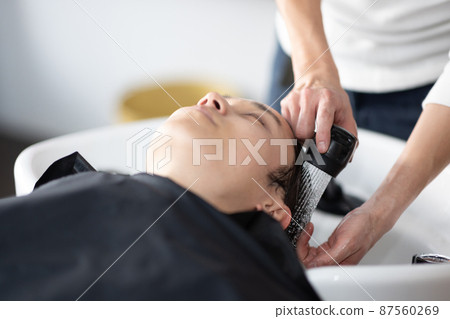 A man who gets shampooed at a beauty salon 87560269
