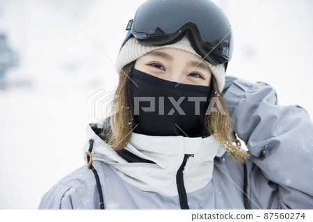 Snowboard girls covering their faces with face masks 87560274