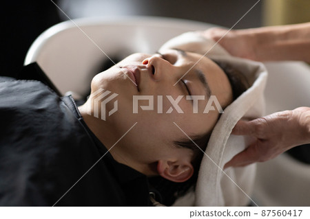 A man who gets shampooed at a beauty salon A man who gets shampooed at a beauty salon 87560417