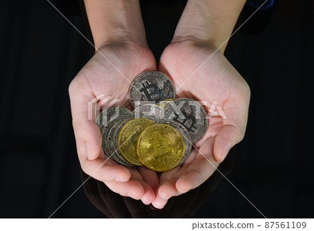 Bitcoin coins in the hand of a  women 87561109