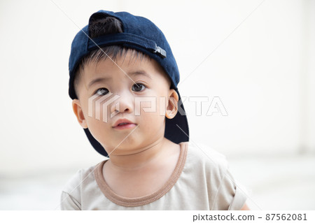 Close up of Asian small boy wearing blue cap and looking at camera 87562081