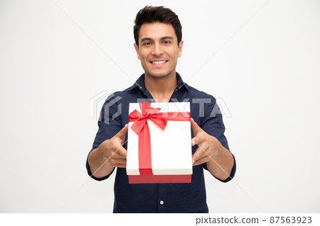Portrait of a handsome young man giving gift box isolated on white background, Showing gift box concept Portrait of a handsome young man giving gift box isolated on white background, Showing gift box concept 87563923