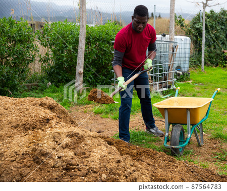 Man farmer with barrow during working with Stock Photo