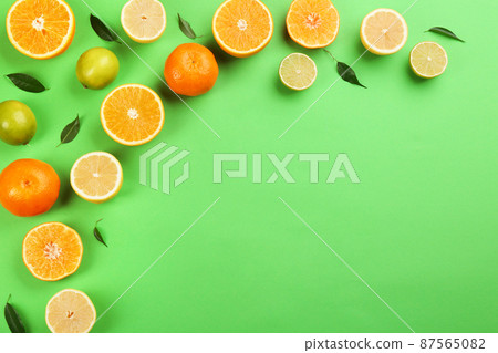 Flat lay composition with tangerines and different citrus fruits on green background. Space for text Flat lay composition with tangerines and different citrus fruits on green background. Space for text 87565082