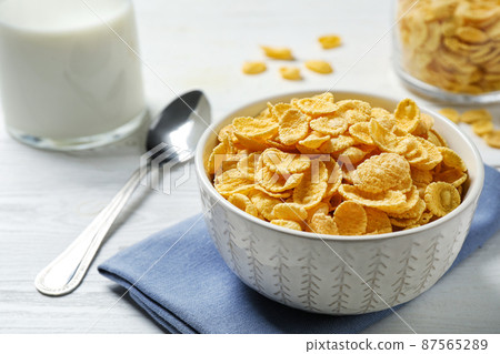 Tasty corn flakes on white wooden table Tasty corn flakes on white wooden table 87565289