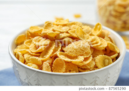 Tasty corn flakes on white table, closeup 87565290