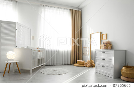 Beautiful nursery interior with white chest of drawers 87565665
