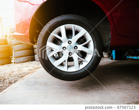 Vehicle hydraulic floor jack raises the car body for repairs in an auto repair garage Vehicle hydraulic floor jack raises the car body for repairs in an auto repair garage 87567123