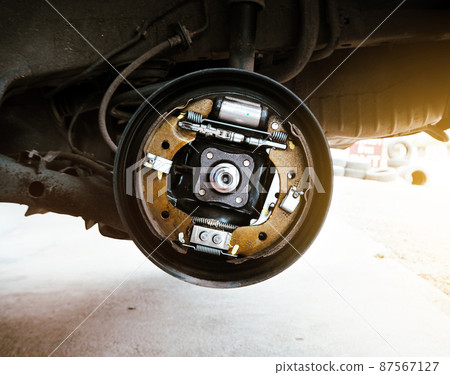 Component inside the automotive brake drum without a wheel on hydraulic car lift Component inside the automotive brake drum without a wheel on hydraulic car lift 87567127