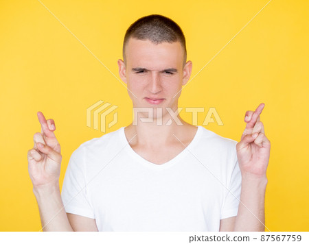 Good luck. Faithful man. Hopeful believes. Handsome concentrated guy crossing fingers asking wish come truth isolated yellow. Good luck. Faithful man. Hopeful believes. Handsome concentrated guy crossing fingers asking wish come truth isolated yellow. 87567759