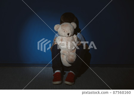 Little boy with teddy bear near blue wall. Domestic violence concept 87568160