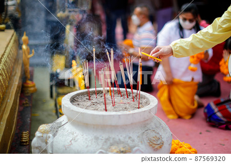 Close focus on lady hand lighting the candle and incense. Close focus on lady hand lighting the candle and incense. 87569320