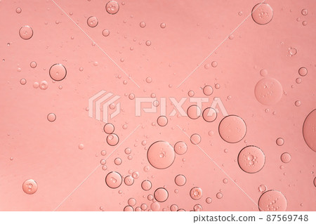 Abstract pink oil bubbles background. Cosmetic liquid beauty product. 87569748