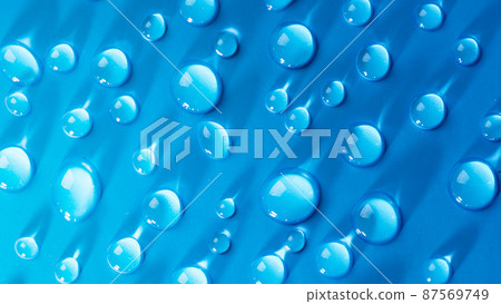 Water drops on blue background. Abstract drops of gel. Face serum cosmetics. Water drops on blue background. Abstract drops of gel. Face serum cosmetics. 87569749