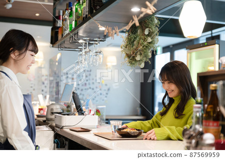 Young female customer receiving pasta at the counter of a self-service cafe Young female customer receiving pasta at the counter of a self-service cafe 87569959
