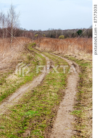 A long road in an arable field. Farmland. A beautiful field road A long road in an arable field. Farmland. A beautiful field road 87573038
