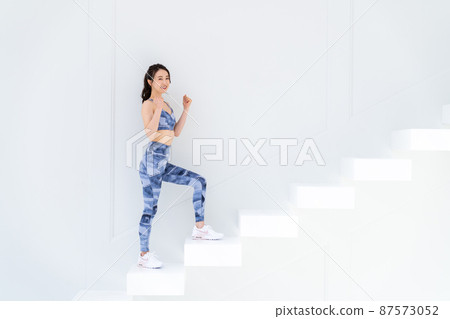 Young woman in sportswear climbing stairs Young woman in sportswear climbing stairs 87573052