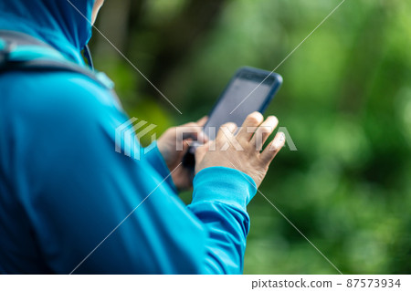 Woman hiker using smartphone  in spring forest 87573934