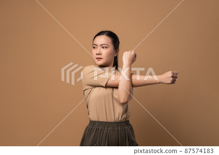 Asian woman was sick with body pain standing isolated on beige background. Asian woman was sick with body pain standing isolated on beige background. 87574183
