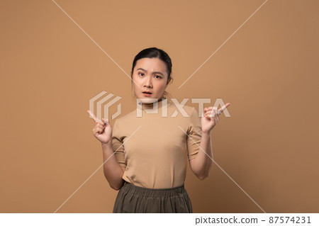 Asian woman feel confuse, standing isolated on beige background. Asian woman feel confuse, standing isolated on beige background. 87574231