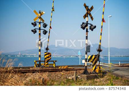 可以看到有明海的鐵路道口三隅線的風景 可以看到有明海的鐵路道口三隅線的風景 87574348