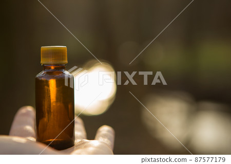 Brown, medical bottle with herbs on the palm. Natural cosmetics - Herbal recipe, glass. 87577179