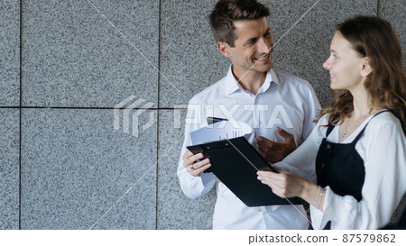 happy employees reading a document while standing on the steps in the office. 87579862