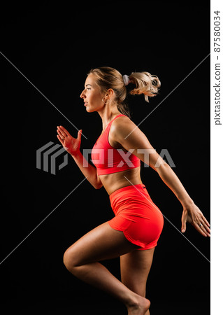 Sporty girl doing exercise with dumbbells, silhouette studio shot over dark and whitebackground 87580034