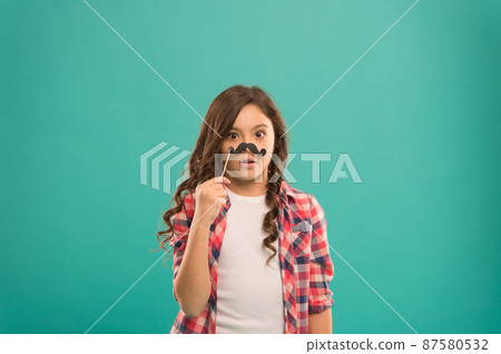 feeling upset. serious kid with funny party moustache. feeling upset. serious kid with funny party moustache. 87580532