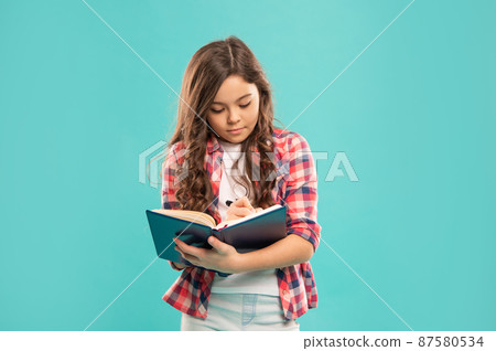 serious teen girl make notes on blue background, education serious teen girl make notes on blue background, education 87580534