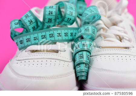 Morning run for health concept. Sneakers with measuring tape 87580596