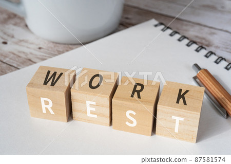 Blocks, notebooks, pens, cups with "WORK" and "REST" written on them 87581574