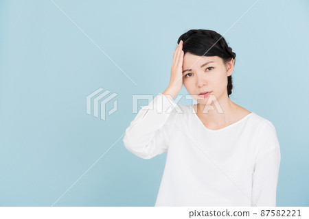 一個穿著白色襯衫的女人,雙手放在頭上 一個穿著白色襯衫的女人,雙手放在頭上 87582221