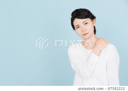 一個穿著白色襯衫的女人,雙手放在肩膀上 一個穿著白色襯衫的女人,雙手放在肩膀上 87582222