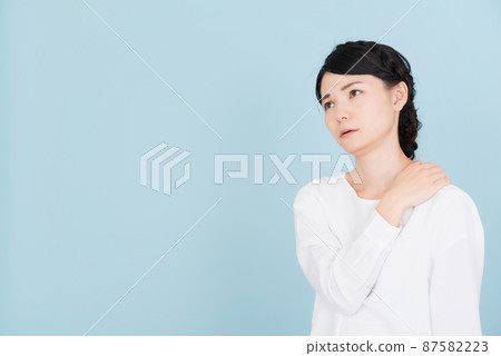 一個穿著白色襯衫的女人,雙手放在肩膀上 一個穿著白色襯衫的女人,雙手放在肩膀上 87582223