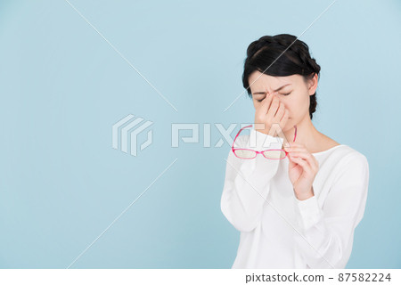 一個穿著白色襯衫的女人，她的眼睛向下 87582224