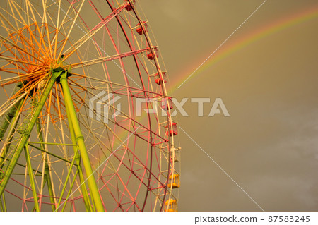 Rainbow at dusk and ferris wheel 87583245