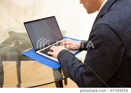 A businessman who works leaning forward as if looking into the screen of a laptop computer A businessman who works leaning forward as if looking into the screen of a laptop computer 87584058