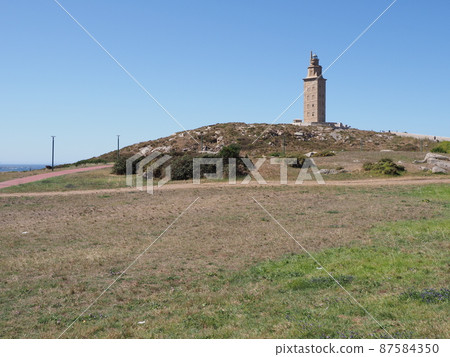 Grassy field and tower of Hercules in A Coruna city at Galicia, Spain 87584350