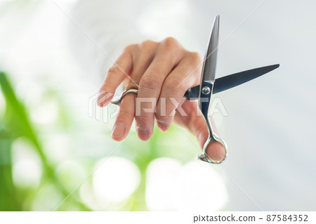 Hands of a beautician with scissors 87584352